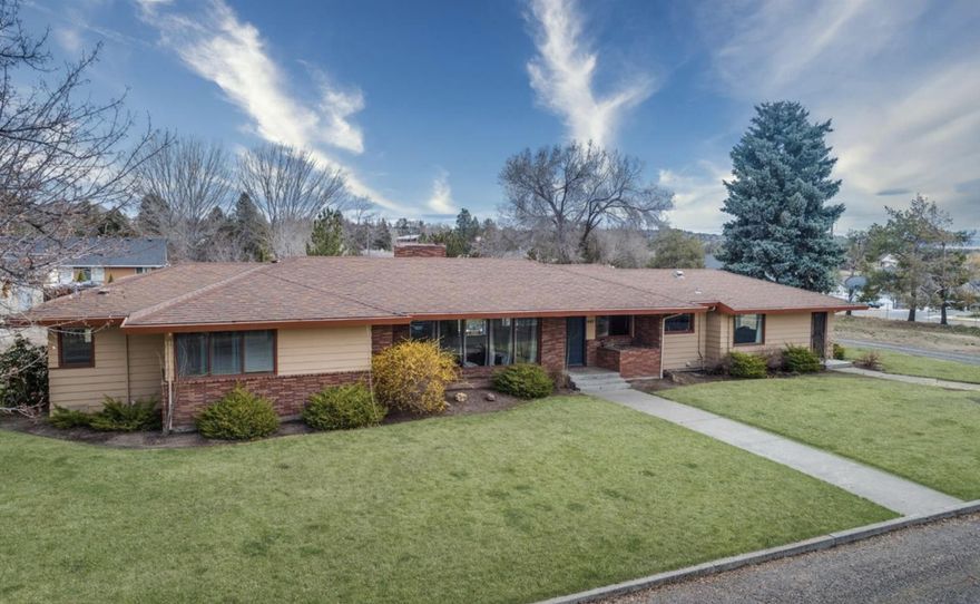 Looking for space & city convenience? This rare 1.42-acre property offers stunning Cascade views & is close to schools, parks, & hospital/clinics. Built in 1958,  3-bed, 2 full (1 located in detached garage) & 2 half bath (1 located in the shop) home offers 2024  sq ft home has been well maintained w/thoughtful updates throughout. The remodeled kitchen features hickory cabinets, granite counters, under-cabinet lighting & s/s appliances. Main bath offers a walk-in shower & Corian countertops. New laminate floors, pellet stove, & extensive rockwork in living room add warmth/charm. Bonus room remodeled into spacious family/flex area. Enjoy outdoor living w/ new deck, large covered patio, water feature, outdoor fireplace, garden, fire pit, & new fencing w/privacy slats surrounding back yard in additional to lot perimeter fencing. Detached double garage plus a newly finished 42x52 shop (built in 2022) featuring 3 bays w/14' doors,including a pull-through bay, loft, storage room & 1/2 bath.