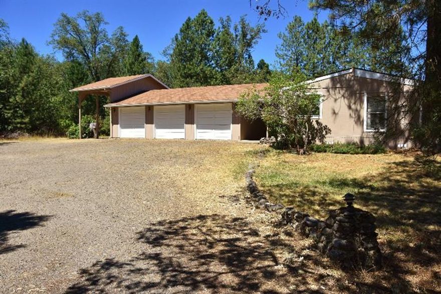 Country living with plenty of room for animals and gardening on this serene 9+ acre property, that is all usable. Private setting with a 2 bed/2 bath 1344 sq. ft. manufactured home that has a 3 car finished garage with shop space inside. Covered RV parking area is a plus. The older 4 stall barn, tack room and corrals sit next to a beautiful open pasture just waiting for the horses to arrive. Good wells in the area. Do not let the address fool you as this property is almost mile from the main road.