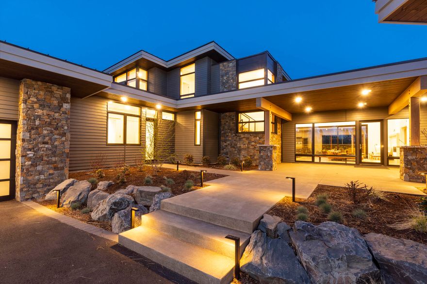 Set on the rise of a premium lot in Tetherow, this stunning contemporary estate blends seamlessly into the high desert landscape. Soaring ceilings & clerestory windows usher in full-day indirect light. Open the oversized sliding glass doors to the private patio w/ fire pit & hot tub. The spectacular kitchen is a chef's dream, w/ authentic Caesarstone countertops, Wolf & Sub-Zero appliances, 2 Miele dishwashers, & abundant storage space. Owner's suite on main boasts patio access & a spa-like bath w/ heated floors, an oversized custom soaking tub, & double vanity w/ Caesarstone counters. An expansive W/I tile shower features dual rain shower heads & hand showers. Four more bedrooms, including 3 en-suites, can be found on the other wing of the home. Enjoy a main-level media room with patio & upstairs flex room w/ access to the large back deck w/ golf and mountain views. Other features of this incredible home include an oversized 3-car garage w/ deep bays & a large laundry/mudroom.