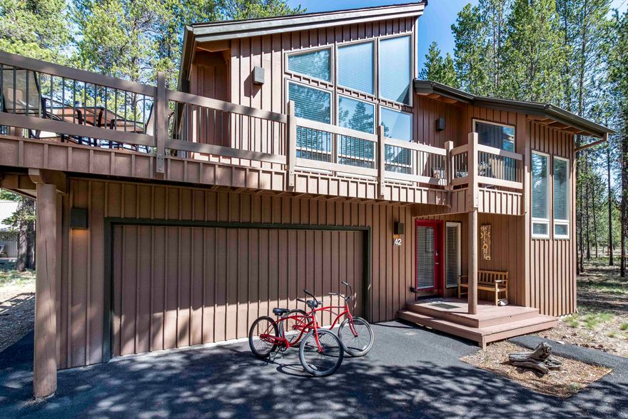 This Sunriver property is nestled in the tranquil north end of the community, surrounded by natural beauty in close proximity to the Deschutes River, Woodland Golf Course, Sunriver owner's pool & Benham Falls trailhead.The reverse living floor plan allows you to fully enjoy the spectacular views of the trees & abundant wildlife from the upper level, which boasts a spacious vaulted great room w/ an open kitchen & a beautiful see-through gas fireplace that connects to the primary suite. You'll love the natural light that floods the home through a wall of windows. Recent updates include cabinet refinishing, appliances, granite counters w/ a tile backsplash, & roof. Downstairs, you'll find 2 add'l bdrms, guest bath, & a fully-enclosed deck for ultimate relaxation in the hot tub. The oversized 2-car garage w/ ample room for your vehicles & toys. Includes A/C &  furnishings. The quiet cul-de-sac location offers add'l privacy & a peaceful retreat from the hustle & bustle of everyday life.