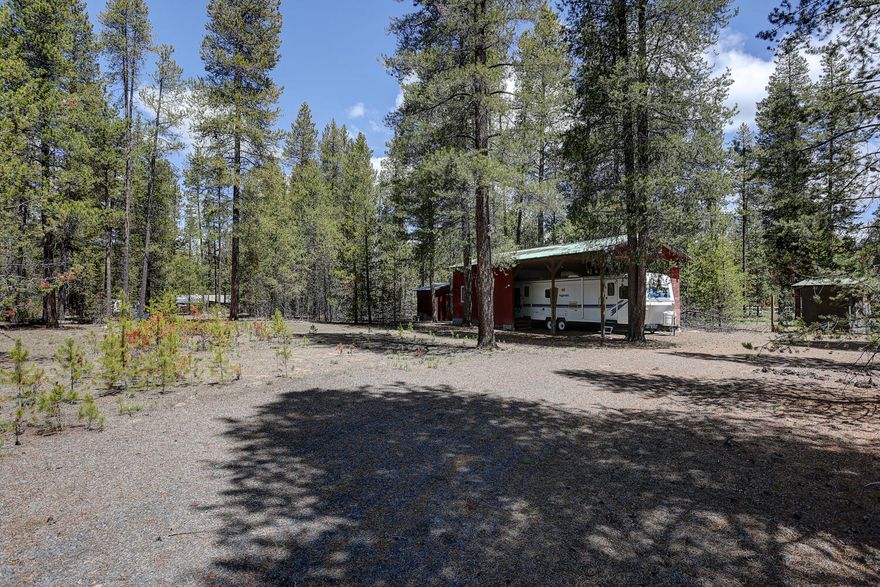 Beautifully treed 1 acre property with electric, septic, and well already installed.  Horseshoe driveway leads to covered RV parking with the RV included with sale.  Property features a bathroom, additional storage buildings, and in-ground sprinklers for your garden.  This property is ready for all your fun!