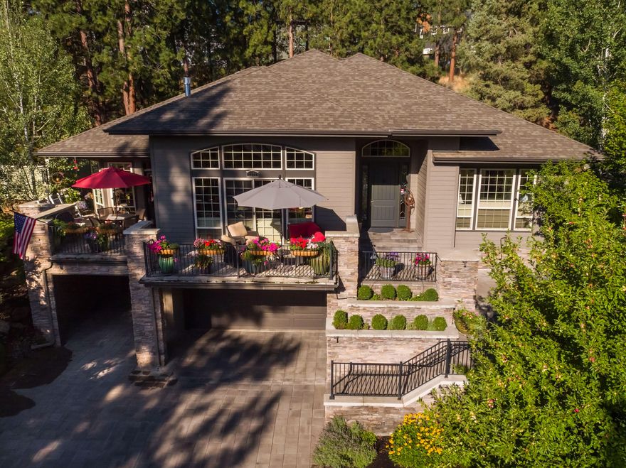 Offers welcome. Set on an elevated private lot in Shevlin Ridge where tall pine trees and outdoor living abound, this spacious and unique home was beautifully remodeled in 2010 to add an additional 500 sq ft of living space. Here, an open layout, soaring ceilings and natural light create an ideal retreat into privacy and elegance, complete with brazilian cherry floors, coffered underlit ceilings and wrap-around paver patio. An open kitchen for entertaining or cooking for a crowd, with an oversized island and luxury appliances. Cozy up in the great room by the gas fireplace and custom hearth, or retreat to the family room with access to the private back patio. On the main floor, the sun-lit primary suite offers a double vanity, claw-foot tub and tile shower, large walk-in closet and two additional bedrooms with jack & jill bath. A lower level ensuite bedroom, media room, or office adds even more space to unwind. The three car heated garage and carport includes room for a workshop.