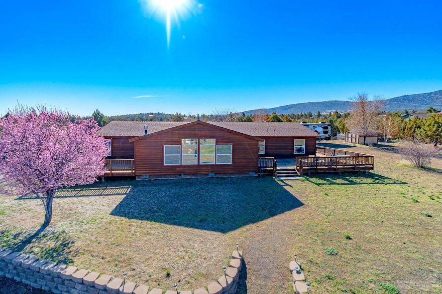 Enjoy wrap around views of the Cascades to Smith Rock, Grizzly & the Ochocos from this private setting. Nearly 6 acres of flat, well manicured land that is great for horses, hobbies & buffer from the real world! Well maintained home w/massive decks for outdoor entertaining was just stained & ready for you. 2,580 sf of open living space in this newer home that's set on a standard foundation & feels just like a stick built home. Huge living & family rooms w/gas burning fireplace w/river rock surround, spacious kitchen w/eating bar & new butcher block top on the central island. Great Master separation w/attached deck complete w/hot tub. Walk in closet, soaking tub & shower too. Huge pantry/storage room off the kitchen. Three additional guest bedrooms & full bath. Outside you'll find a 3 bay heated shop w/space for all your toys! Private well w/water storage, full hookups for RV or hardship dwelling. Fully fenced, cross fenced & situated in desirable Powell Butte. Don't miss!