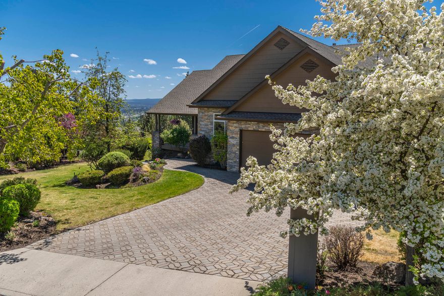 Peaceful and private setting on half an acre of beautifully landscaped level grounds. Expansive partial wrap around deck for entertaining and enjoying the city views & 4th of July fireworks! Optimum location just minutes to downtown with easy access to restaurants & shopping. Entering the front door you are greeted by soaring ceilings and large windows to capture the views. Cozy up by the fireplace in the great room. host a formal dinner party or keep it casual in the kitchen dining. Hickory cabinets, travertine backsplash and built in hutch to accompany the built in fridge and new dual fuel stove. Main level features primary bedroom with French doors to bathroom with jetted tub, dual vanity and large walk-in closet. Laundry with sink off of garage. Huge Bonus downstairs with private bedroom and bathroom. Easy to maintain paver driveway, exterior steps, lower patio. Oversized three car garage with workbench.