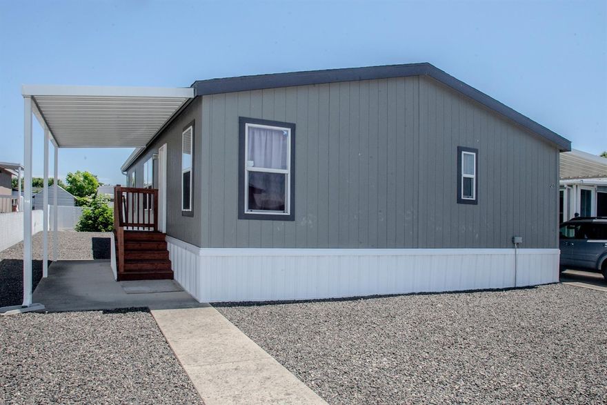 Looking for a newer well-maintained home in a 55+ park? Here it is in Sunset Estates! This lovely home was built in 2014 & has been lovingly cared for by original owner. 3-bedroom 2-bath home has desirable split-bedroom floor plan with master suite tucked away at back of the home. Living area is a spacious & open style--light & bright with attractive kitchen cabinets. Off the dining area is a good-sized laundry room with utility sink & exterior access to the carport. Refrigerator, microwave, washer & dryer included (new 2014). Retractable screen door on both front & back. Low maintenance yard with garden space in sunny backyard; seller enjoyed delicious fresh vegetables from this garden spot in years past. North-facing front-entry covered patio area is 12'x20' with a concrete pad. Long driveway can park 3 cars (2 in tandem covered by 12'x40' carport). Large shed 12'x8'. Reasonable space rent currently $346/mo, which includes sewer & garbage. One pet allowed (20 lb max).