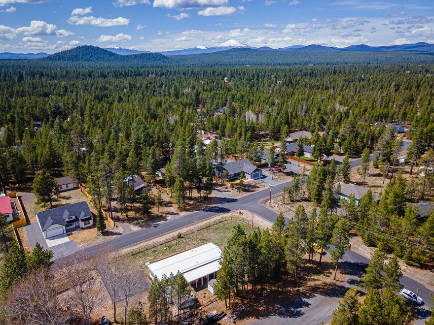 Manufactured home in the serene Oregon Water Wonderland community with a community dock and river access; Three Rivers area. The open floor plan, oversized windows, and updates create a welcoming atmosphere, filled with natural light. The property features a fully fenced, level grassy lot, two paved gated entrances, three wooden sheds (two with power), a fenced garden area, raised beds, fire pit, carport, and mature trees for beauty and privacy. The well-maintained home includes a replaced roof, freshly stained front deck, hot tub, wood-burning stove, and ample parking. Inside, find luxurious vinyl flooring, remodeled bathrooms with shiplap, wainscoting, new vanities, light fixtures, and tile floors. All appliances are included: washer, dryer, dishwasher, refrigerator, glass-top stove, double oven, and outdoor hot tub. Main and second bedrooms offer walk-in closets and en-suite bathrooms. This charming home perfectly combines comfort and style in picturesque Oregon Water Wonderland