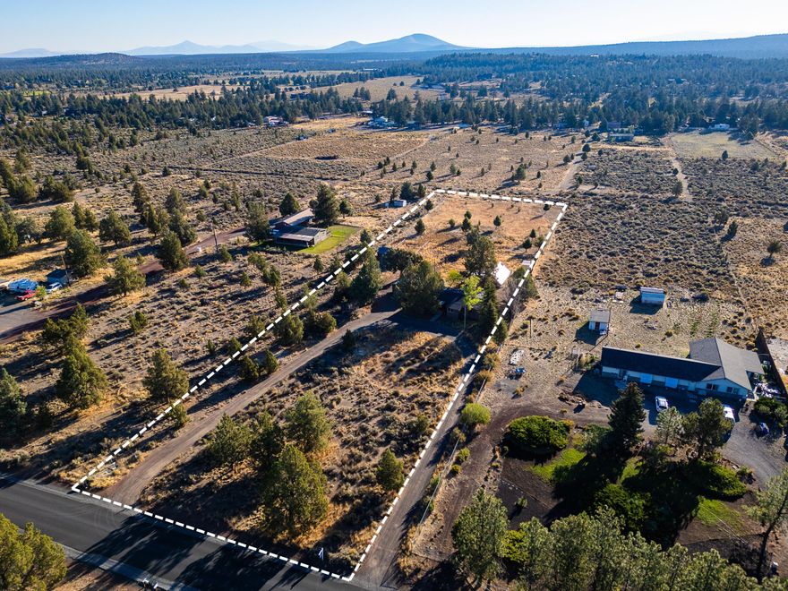 Situated on 2.21 acres in the desirable Sun Mountain Ranches, this property is a rare opportunity to create your dream home. The existing manufactured home can be removed, allowing you to build a custom residence or bring in a new manufactured home that fits your style. With no CC&Rs or HOA, you have the freedom to design and use the property as you wish. Features include a horseshoe driveway, two horse paddocks, space ready for a 60' round pen, a barn with chicken coop, and a 15'x30' greenhouse—ideal for gardening and hobby farming. A detached 2-car garage, RV hookups, shared well, septic, and power are all in place, making development more achievable and cost-effective. Located minutes from Sisters and Bend with quick access to Highway 20, this property offers privacy, convenience, sweeping Cascade Mountain views, and the flexibility to bring your vision to life.