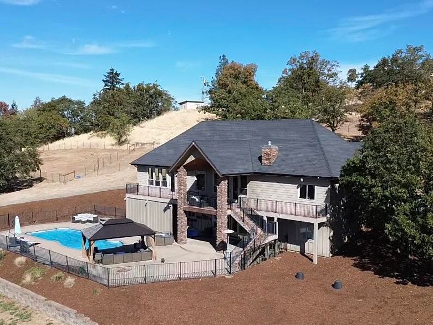 Discover the perfect blend of country living, close to town, in this well maintained 4-bedroom, 3.5-bathroom home in the highly desirable Griffin Creek area. This home features a living room and family room, office, and a theater room that can easily transform into a 5th bedroom.

Step outside to your personal oasis with a heated pool. Equestrian enthusiasts and hobby farmers will be delighted by the outdoor riding arena and new barn, equipped with 3 horse stalls, a tack room, hay storage, and multiple small animal stalls, which can be converted into additional horse stalls as needed. The property also boasts a large two-story shop for all your storage and workshop needs.

Situated on a fully fenced 5.48-acres, this property offers privacy and ample space for outdoor activities and animals. Experience the best of country living with all the modern amenities and conveniences you desire. Don't miss the opportunity to make this dream property yours!