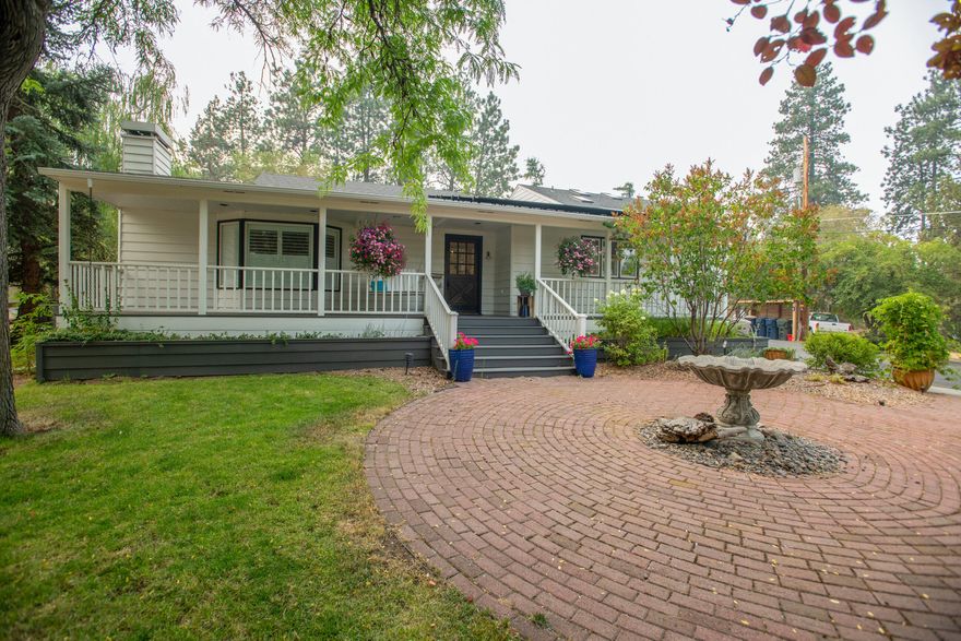 Mid-Town Oasis on 2.07 acres showcasing a lovingly cared for and thoughtfully updated home. The owners have spent the last 12 years fine tuning this beautiful home, inside and out, from a stylish gourmet kitchen featuring solid surface counters, eating/cooking island, custom cabinets and a subzero refrigerator, to a private attached VRBO suite with hot tub and deck that generates a considerable amount of income per year, while solar panels keep the utilities at minimum. Set back on a long, paved driveway surrounded by mature trees and landscaping, providing a feeling of privacy with the convenience of in-town living. An irrigation stream runs through the property near the barn and fenced field. This property has multiple investment opportunities as well. Zoned RM, it can be developed in a variety of ways including partitioning the back (West) 1 acre off, while maintaining a current oasis in front. Country living, city convenience, potential development/investment -- This is it!