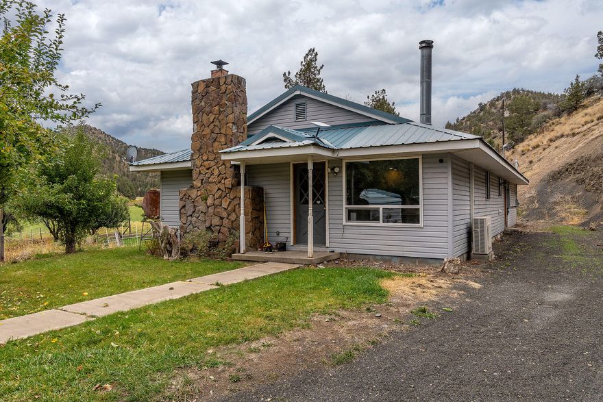 Rural ranch setting on 48.64 acres, ideal for cattle and livestock. Fully fenced and cross-fenced pastures with water rights from West Branch Creek and a large irrigation pond with wheel and hand lines. The 3 bed, 2 bath farmhouse features a spacious open living area with oil monitor heater and wood stove insert, plus a mini split for year-round comfort. Antique cook stove adds charm to the large dining room. Kitchen includes pantry, ample storage, and a generous eating bar. Set up for animals with a small barn, tack room, corrals, hay storage, meat cooler, poultry coop, and fenced orchard and garden. Includes a large insulated/heated shop with 10' door, detached carport, and a multi-use shed for hay or wood. A true turn-key ranch property.