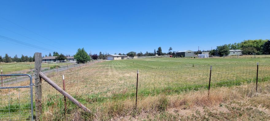 Perfectly located 2.65 acres with septic system, private well, and 1 acre of irrigation only minutes to Bend, Redmond, & Tumalo! Get away under a million stars - yet so close to Trader Joe's, Home Depot, Best Buy, and soon-to-be-built Costco! 184'x627' fenced, flat parcel backs to a path and beautiful seasonal canal.  2 car garage built in 2002. Bring your vision and make your Central Oregon dream home a reality! Older manufactured home on property needs work and will not qualify for conventional financing due to age of  home - Seller prefers cash offers.