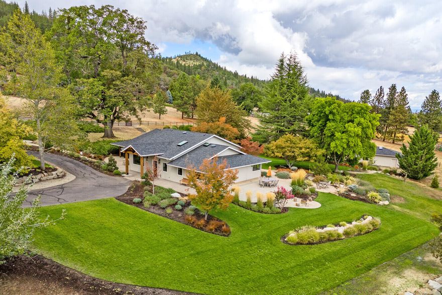 Amazing oasis nestled on 5 acres w/Mt. McLoughlin views & newly landscaped parklike grounds, only 3 minutes from Jacksonville! The spacious, tastefully updated, single level home oozes comfort for you or guest w/multiple living areas inside & out. Relax in split floorplan w/versatile great room showcasing high ceilings, brick floors & abundant natural light. Delight in the kitchen w/new counters, backsplash, appliances, breakfast bar & convenient to blt-in bar & dining room. Master suite features sitting area, walk-in closet, marble & tile bath w/soaking tub & shower. Home includes 2 additional large bedrooms, a 3rd full bath & laundry rm. New roof, wood doors, A/C units, WI-FI, 2nd well (2-2500 gal holding tanks), patios & lighting, Bocce Ball court & firepit. Property's circular drive also accesses 4 car gar & heated/cooled building for guest or teen hangout w/full kitchen, bath & living/bedroom. A pasture for animals or more privacy. Tour today; you'll never want to leave!!