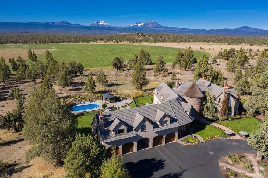 From the moment you pass through the iron gates at 18299 Snow Creek Lane, you know you're somewhere special. This incredible estate between Bend and Sisters features travertine and mahogany floors, vaulted ceilings, and custom touches throughout. Two living areas on the main level offer framed views of the Three Sisters Mountains, and allow access to the heated pool, multiple patios, and hot tub. A well-appointed chef's kitchen opens to both living areas. A study/library off the living room includes a built-in desk and gas FP with origins in England. Also on the main level, you'll find the Master, featuring a large walk-in closet, double shower, & soaking tub. Upstairs, find a large game room with and deck w/ views, as well as a large media room, featuring theater seating (negotiable) and A/V equipment (included). Three more guest suites, including one with its own separate entrance, are also upstairs. Outside, find an attached four-car garage and detached 2496 SF shop w/ lift.&nbs