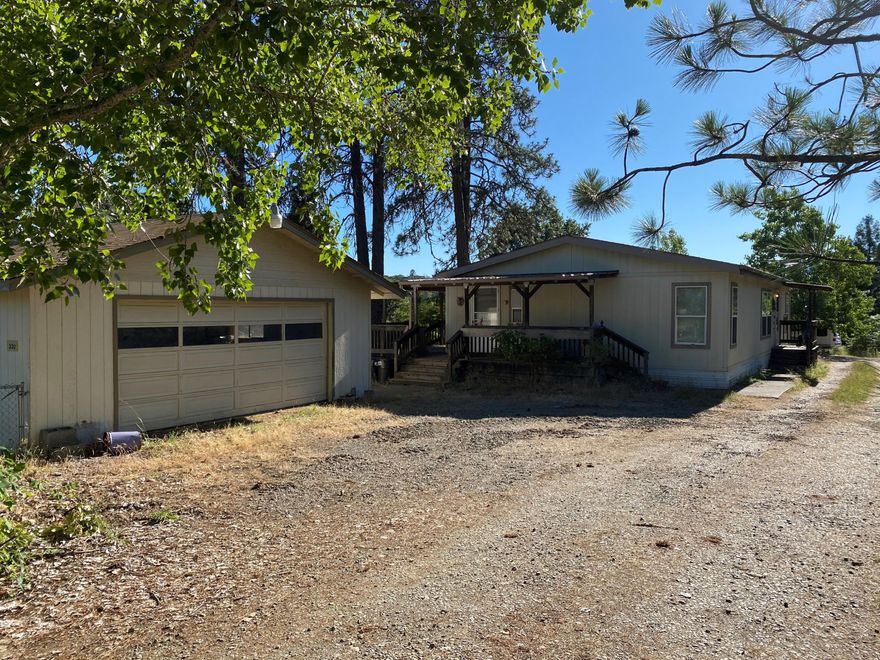 Come enjoy this 3 bedroom 2 bath home in a country setting on   3.56 beautiful acres located conveniently close to the Merlin Airport. The house is a 1,296 square foot 1997 double wide, featuring skylights, ceiling fans, vaulted ceilings,  a split floor plan and open concept living and kitchen area. The master bedroom has vaulted ceilings and a master bathroom with a large easy walk-in shower.  Outside you can enjoy the views of the mountains and 2 fenced pastures on the wraparound deck.  Don't forget to relax by the shaded Koi pond.
