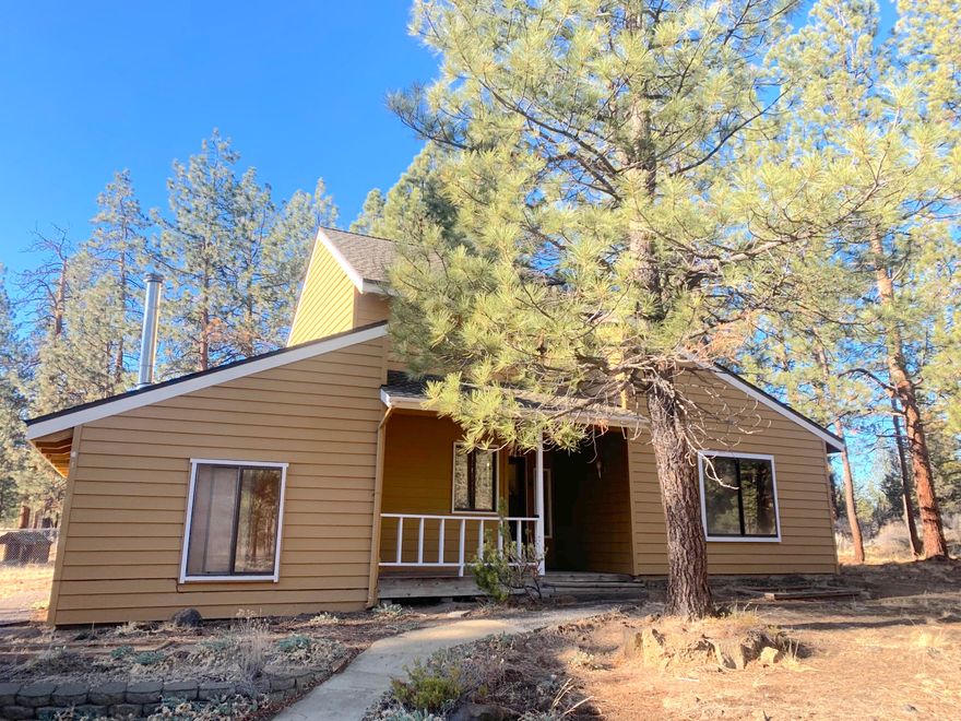 Enjoy your privacy in Woodside Ranch! Plenty of space to make a garden, park your RV/Boat, or build a shop, including dual access via China Hat Road. This home has just been recently painted inside, new flooring throughout, new toilets, new lighting, new range, new dishwasher and new microwave! Whole new septic system too!
Two wood stoves keep it nice and cozy on those cold winter nights. 
Main level has open floor plan with vaulted ceiling in living room and natural wood walls throughout. There is an extra ''bonus room'' with it's own entrance and wood stove. 2 bedrooms, laundry and full bath are also on the main level. Upstairs is a loft bedroom with full bath featuring a nice soaking tub. Outside there is a two car detached garage as well as a gazebo (could be a 3 season porch) and a fenced dog area. The house gets plenty of sunlight and is just minutes from BLM land for your adventures, as well as Highway 97 for your necessities.