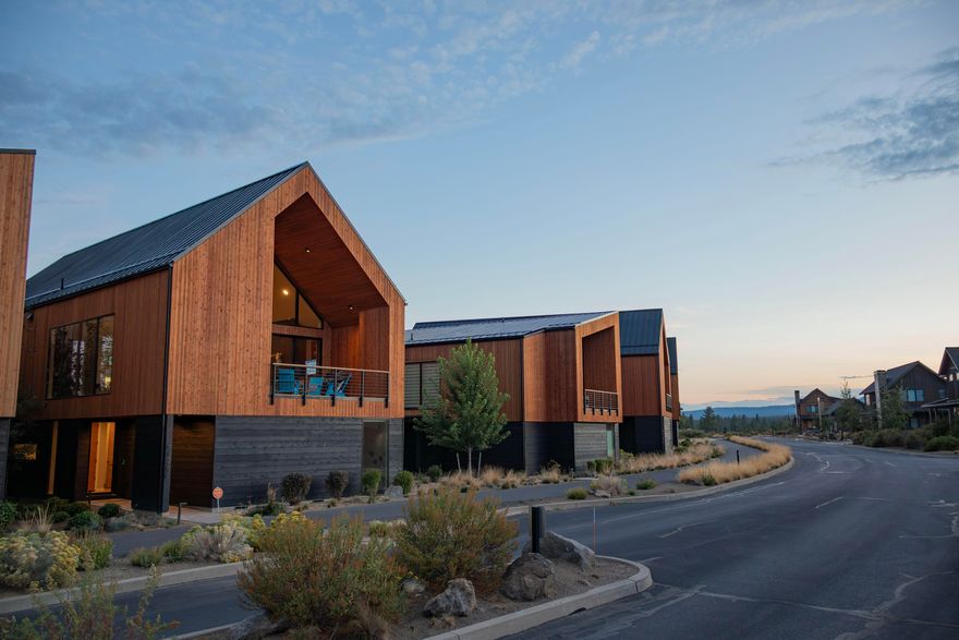 Experience modern mountain living in this stunning Scandinavian-inspired chalet, completed in 2021 and nestled in the heart of Tetherow. Designed with a reverse-living layout to capture sweeping mountain views, the upper level features vaulted ceilings, a sleek glass fireplace, and sliding glass doors that open to a covered deck for seamless indoor/outdoor living. The gourmet kitchen includes quartz countertops, custom cabinetry, and premium Thermador appliances. The spacious primary suite offers floor-to-ceiling windows with panoramic eastern views, a walk-in closet with its own washer and dryer, and a spa-like bath with a soaking tub and luxe finishes. The entry level offers two ensuite bedrooms, a large mudroom, and an oversized three-car garage. Clean lines, natural materials, and abundant light define this thoughtfully designed home, just minutes from world-class trails, golf, dining, pools, and easy access to Mt. Bachelor and Bend's vibrant west side.