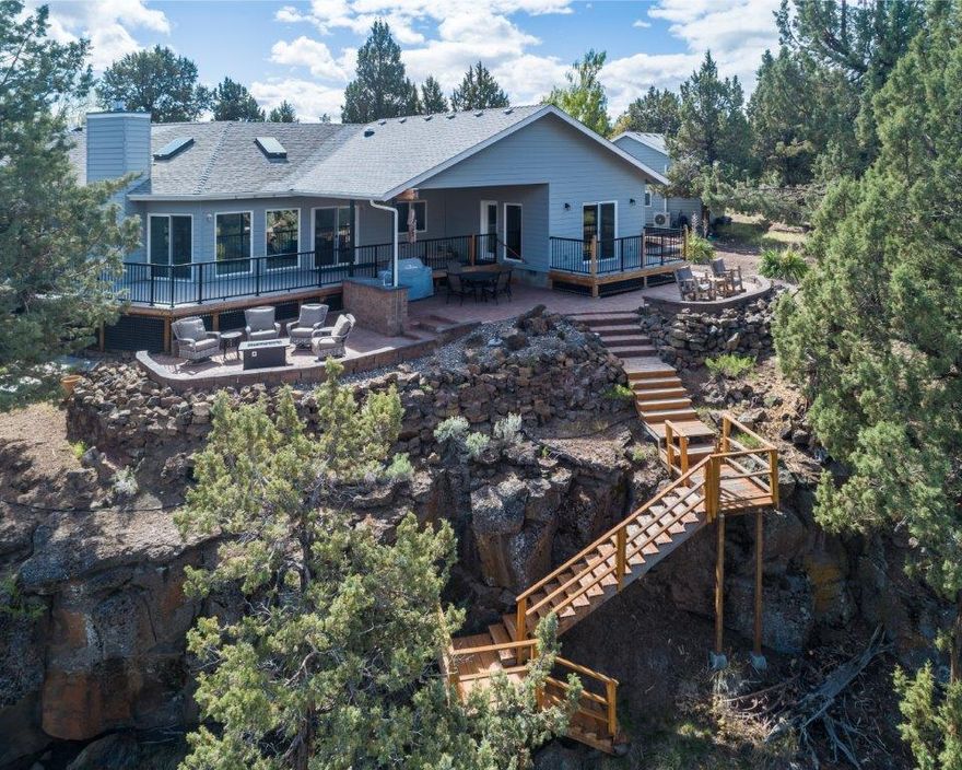 Beautiful home on the river with access from the property. This lovely 3 bedroom, possibly 4, home has wonderful views from just about every room. A wall of windows on the west side, open up to dramatic views of the river and the adjoining hillside. Sit on the new deck or beautiful paver patio and watch the Eagles play in the river. There is a wood stove in the living room to keep the chilly nights at bay. Vaulted ceilings in the kitchen, dining and living room make the open floor plan very enjoyable. Office area off the kitchen makes it very easy to work from home. Additional bonus/guest room has it's own access to the deck and views of the river. Attached to the house, is a finished 3-car garage. There is also a detached, finished 2-car garage. In addition, there is a 30x60 RV garage that has shop area and a wood stove. This lovely, single level home resides in a gated community.