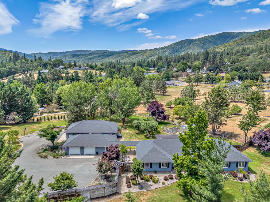 Fully furnished, 2-acre estate, with guest quarters and a large shop in historic Jacksonville. Pair-A-Dice Ranch Road is known for its lovely country setting and beautiful homes. This home features large living areas, high quality finishes like travertine tile kitchen floor and a 2-sided fireplace. The primary bedroom is spacious with a walk-in closet, marble shower and dbl. vanity. Outside is a gated entrance to a huge, paved parking area, and a detached 2-car garage with an attached guest room with full bath. Enjoy a separate 30'X50' shop building with 10' ceilings, boasting an air compressor, work benches, 220-amp service and room to play. The driveway is gated, and the yards are well cared for with complete irrigation system from a high producing well (home is on city water), and there is a high-quality climate-controlled greenhouse to grow food year-round. This property is well cared for and is a rare find in Southern Oregon, located 2 minutes from The Britt Music Festival.