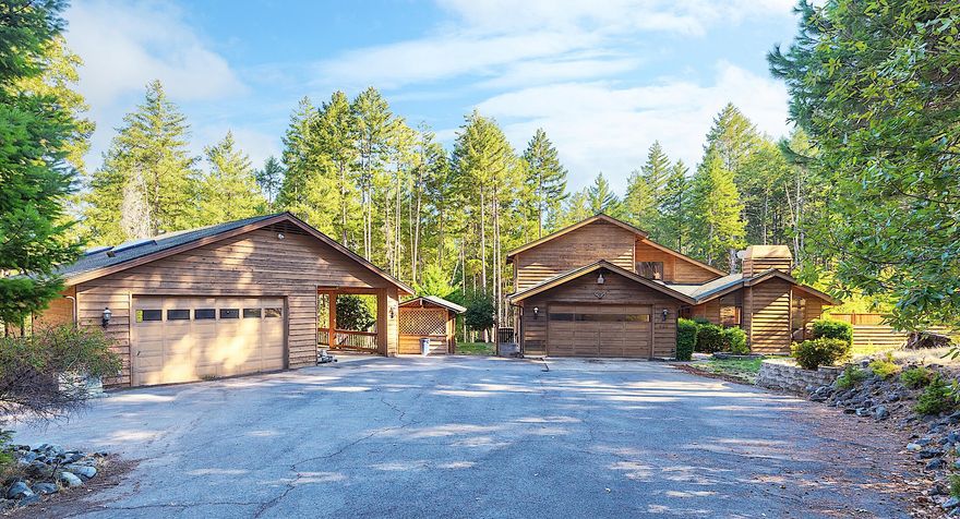 NEW PRICE! $50,000 price reduction. Welcome to 445 Bonnie Lane, a beautifully maintained 2,469 sq. ft. cedar home nestled on 2.73 acres in a peaceful forested setting. Located at the end of a quiet cul-de-sac, this 3 bedroom, 2.5 bath home offers an open, functional layout with a lodge-style feel. The main level primary suite includes a walk-in closet, soaking tub, and private deck accessing the backyard. The sunken living room features tall ceilings and a cozy vibe, perfect for relaxing or entertaining. A spacious kitchen with tile counters flows into the dining area and bright sunroom, creating plenty of space to gather. Outside, enjoy mature landscaping, room for gardening, a large extra deep two car garage/shop, and covered RV parking with 30-amp power. With easy access to town, this property offers the perfect mix of privacy and convenience. Come see what makes this home and setting so special!