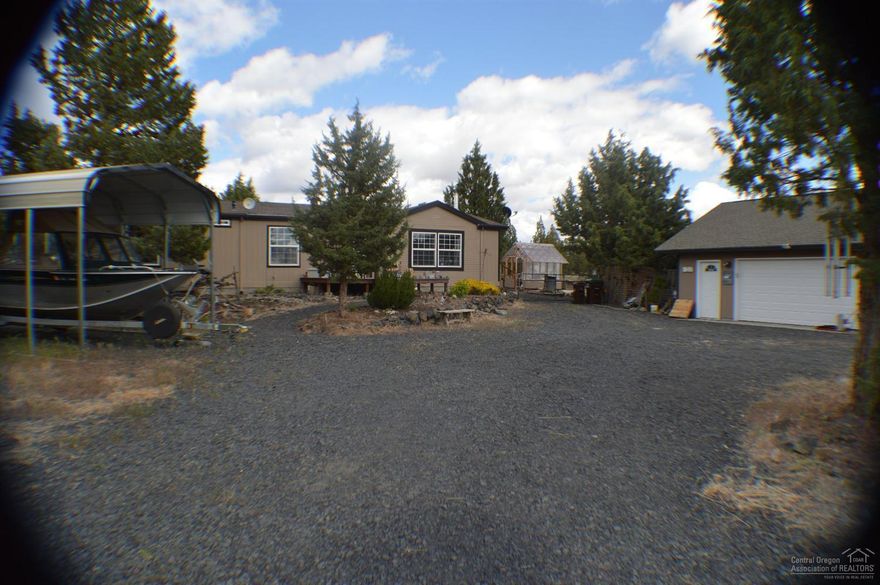 Gorgeous mountain view from 1.81 acres, 1617 sq ft, 3 bed/2 bath mfd, large kitchen, spacious living room, vaulted ceilings, freestanding woodstove, formal dining with bay window, heat pump. Enjoy the outdoor patio, deck, greenhouse, garden area, fruit trees, berries, chicken pen, boat/car cover, large detached 2 car garage with workshop area, private well, gated entry with large rocks lining the gravel driveway. Close to the Ochoco and Prineville Reservoirs for fishing. Backs up to BLM.