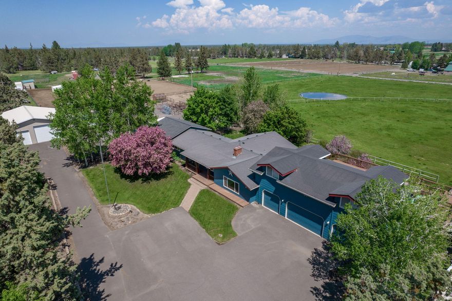 Country living at its best, just outside city limits, enjoy the country while being close to shopping, parks and schools. Featuring a spacious east facing primary bd with fireplace, large shower and soaker tub. The kitchen is the heart of the home flanked by bdrms, office, bonus room and large laundry. The large eat-in kitchen has granite counters and is open to dining room with gas fireplace. 1 bdrm, bath and bonus room are in south wing perfect for multi-generational living or potential for separate unit. The attached 4-car garage has an additional 900 sqft of flex space above. This property is perfect for a home business or hobby farm with 3.88 acres of irrigation, distributed from a pond through in-ground and k-line sprinklers. Outbuildings include 2 insulated, heated shops (2,112 sq ft and 1,440 sq ft), green house and barn. One shop fits a motor home the smaller shop has 4 garage doors perfect for a car enthusiast. Bring your animals and make this your home.