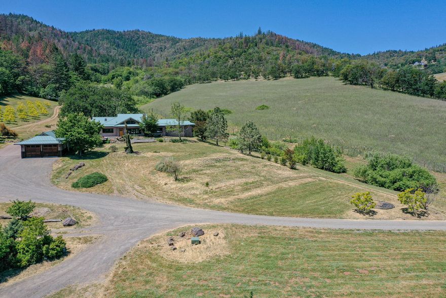 Discover life in this custom designed and built masterpiece nestled on 100 plus acres of pristine land. Beautiful mix of pastures and hardwood forest.This 3700 sq ft haven
boasts copper gutters, a metal roof, and an additional approved homesite with septic installed . Step on locally sourced madrone and custom tile floors with radiant floor
heat beneath, vaulted ceilings, bask in the warmth of a rock fireplace with certified insert and marvel at custom doors and built-ins. High end aluminum clad wood windows
throughout .The master suite offers a spa-like walk-in shower and sunken tub. For guests, a separate entrance with a full bath promises privacy. In the finished oversized
2-car garage lies a quiet home office . Multiple outbuildings, including a two-story barn with radiant floors and a finished second floor of rough
sawn local wood, maximize the property's potential.Outdoors, enjoy an orchard with 300 fruit and nut trees and custom in ground pool. Great horse property also.