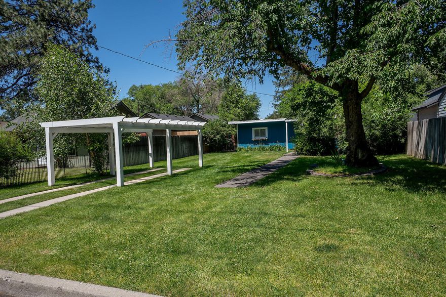 Come to ''Cherry Tree Cottage at Wiestoria''  in the heart of Mid-town Bend.  Solid home tucked into a sweet quiet treed area on paved street, close to shopping, restaurants, parks, medical, & everything ''Bend''.  Private spacious 140' lot features cherry, elm, birch, flowering plants, & lawns. Spotless appealing charm in this 2 bedroom, 1 bath beauty, 829 sq.ft. + a nearly 400 sq.ft. guest cottage.  Covered patios in the fenced-sprinkled-gated-landscaped backyard, & wonderful large pergola in front. Eat-in kitchen is open to the living area; updated windows all around for natural light, utility & pantry area for ideal storage.  Served by newer gas furnace, water heater, plus alarm system.   Guest cottage is perfect for hosting with full bath, vaulted ceiling, & doubles as a perfect home office, served by electric heat, spacious back entry hall, large garden shed attached, with an extra alley entrance & parking.  You'll fall in love with this excellent value in popular Mid-town Ben