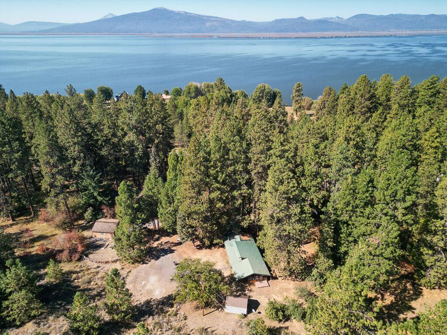 Welcome to 3623 Cahuilla, the beloved ''Rock House'' where relaxation, retreat, and adventure await. Just steps from Agency Lake, this 3-bedroom, 2-bath, 1,208 sqft home blends rustic charm with modern updates. Inside, enjoy soaring clerestory windows, exposed beams, cedar tongue-and-groove finishes, LVP flooring, a newer wood stove, modern appliances, and shaker-style cabinetry. The living room is wired for surround sound. Outside offers a covered porch, new fencing, 2019 septic, detached 2-car garage on its own lot, and a finished 8x16 shed—perfect as a studio, workshop, or storage. Fruit trees include cherry, pear, two apple, and plum. HOA covers road maintenance, snow plowing, and community well—no water bill. Residents enjoy lake access, boat ramps, and parks. With a durable metal roof and prime location near the Wood River Wetlands, this home is ready to enjoy for years to come.