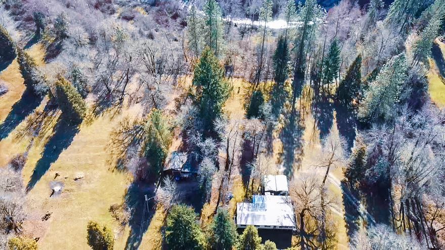 Private, usable and beautiful this property is less than 5 minutes to i-5. Property is surrounded by several varieties of mature trees and has a approx. 4 acres fenced for animals. Looking for waterfront? Year-round Graves Creek runs through this property. Live in the 1973 double wide while you build your Dream Home. Good producing well per sellers. Fence line is not property line.