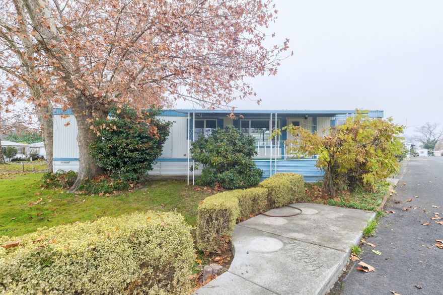 New listing in Riverhaven Mobile Home Park, a welcoming 55+ community. This 1977 home has been beautifully refreshed with new interior paint and durable LVP flooring throughout. Enjoy a covered front deck that overlooks the spacious community park—perfect for relaxing outdoors.  The 728 sq ft floor plan includes 2 bedrooms, 1 bathroom, a comfortable living room, and a bright kitchen with adjoining dining area. The hall bath features a tub/shower combo, and the home is equipped with washer/dryer hookups for added convenience.  Additional features include vinyl windows, forced-air heating and cooling, a covered carport, and exterior storage. Monthly space rent is $487.00.