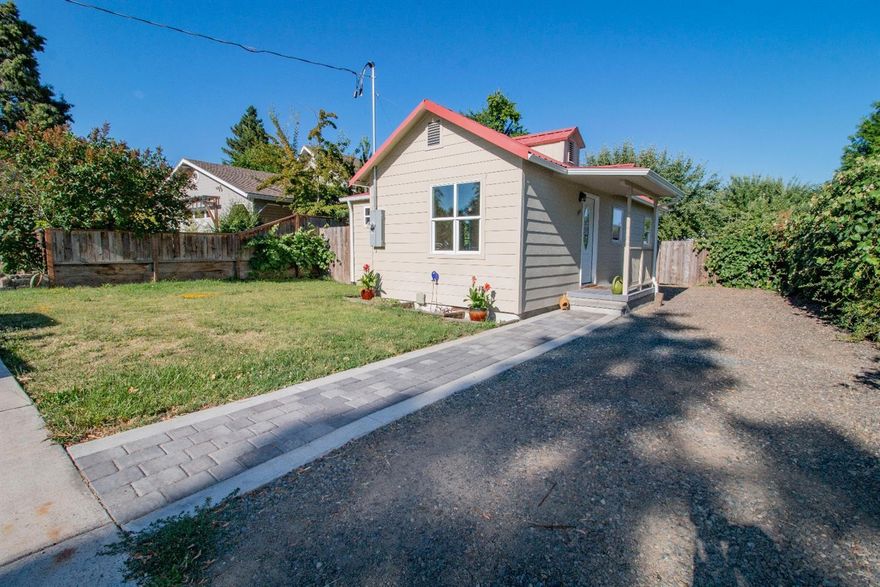 Super cute cottage, conveniently located between Ashland and Medford. Updated and move-in ready, this home has all-new plumbing, including sewer connection to the street, and water heater; new 200-amp electrical service; new vinyl windows; newly tiled floors in the bathroom, utility room/3rd bedroom, and front porch; new laminate flooring; and recently updated kitchen with granite counters, new cabinets, and Kohler farmhouse/apron sink. The backyard has gorgeous, mature trees, storage shed with electric power, planter area for garden, and alley access. Per seller, City of Talent planner suggested possibility of building a second residence at the back of the property, so could be great potential for investment. Buyer to do due diligence with the city and/or county with regard to ADU. Easy to schedule, so give us a call to tour it today!