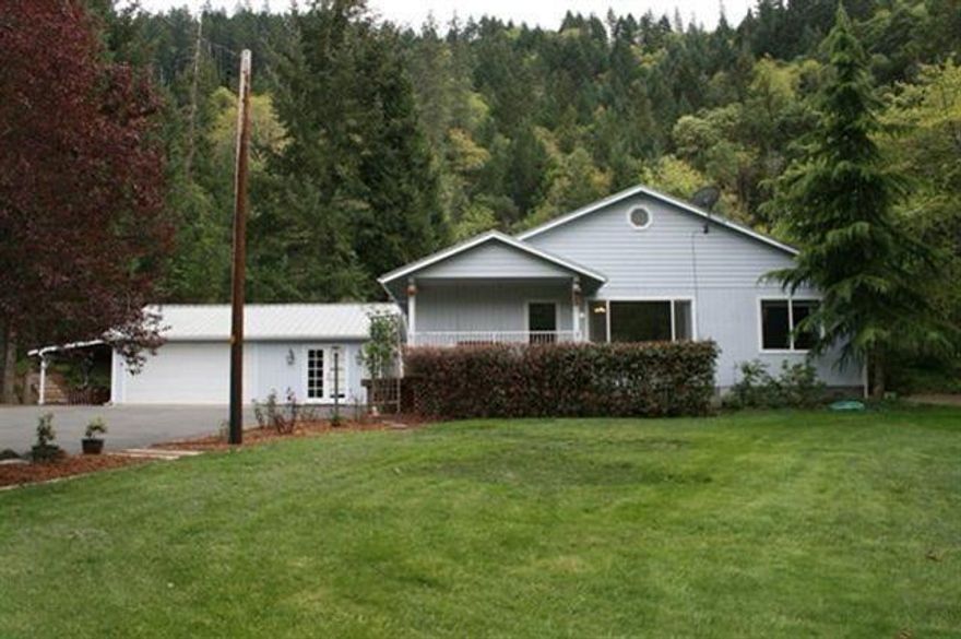 Life on the Rogue! Beautiful Rogue River front home on 5.63 acres. Built in 96, the home features 2 bedrooms plus an office/craft room off the garage, 2 baths, bright living room with vaulted ceilings, hardwood floors and view of the river, formal dining room, great kitchen with Corian countertops, island and plenty of cabinets. The detached garage is close by with an office/craft room and laundry room with utility sink. The exterior features also include a 30 x 25 RV port, relaxing covered deck, beautiful landscaping, fenced garden area, chicken coop and paved driveway. Fish and frolic on the sandy beach on a nice bend in the river! Is this YOUR new home?