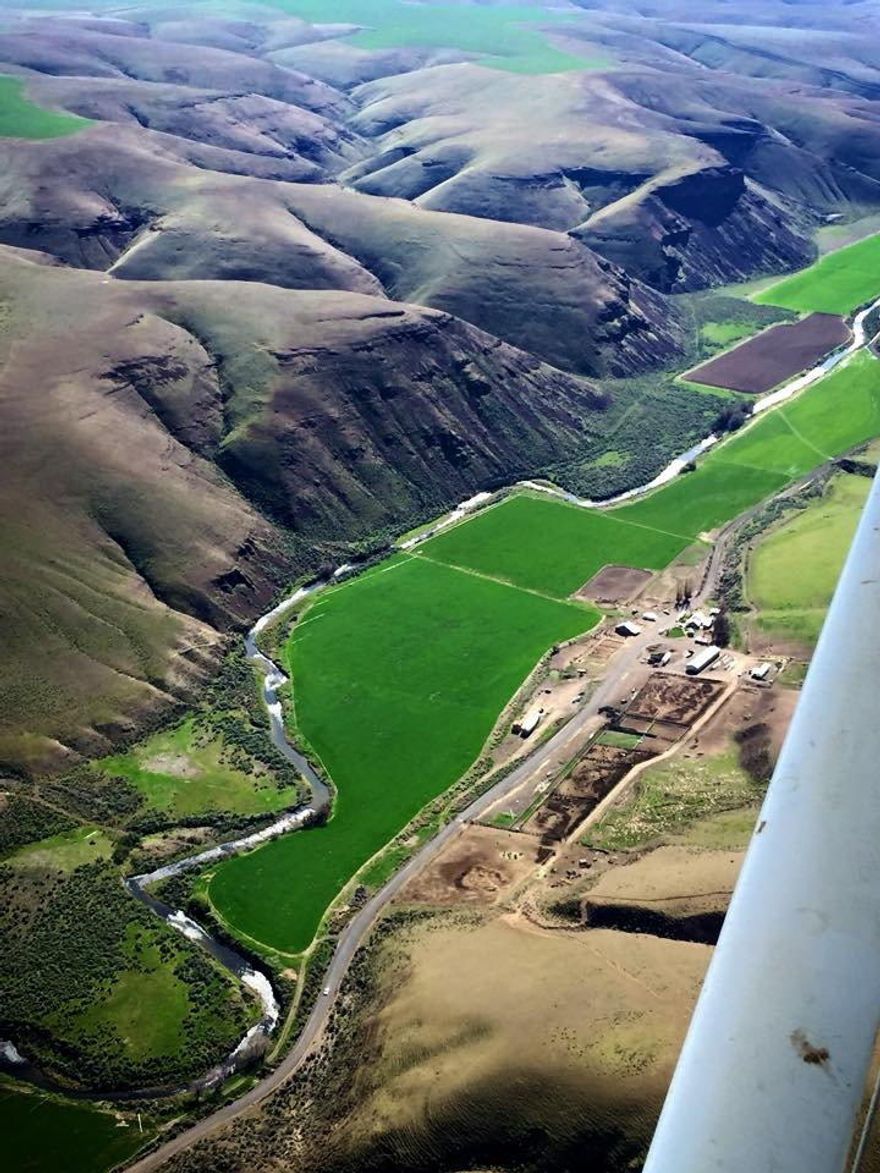 Privately situated in Picturesque Rock Creek Canyon, this 6,098 acre ranch offers all that rural country living in Oregon has to offer.   This working hay and cattle ranch includes 202.5 acres of primary water rights from Rock Creek plus additional supplemental rights from 3 ground wells on the ranch.   There are an additional 67 acres of dryland farm ground which recently has been leased to and farmed by the adjoining neighbor.  The remaining 5,829 acres consists of the homestead, shop and barn areas with the balance in native dry land range.  Elevation of the ranch ranges from 1200' on the creek bottom up to 2,400' at the south end of the ranch.