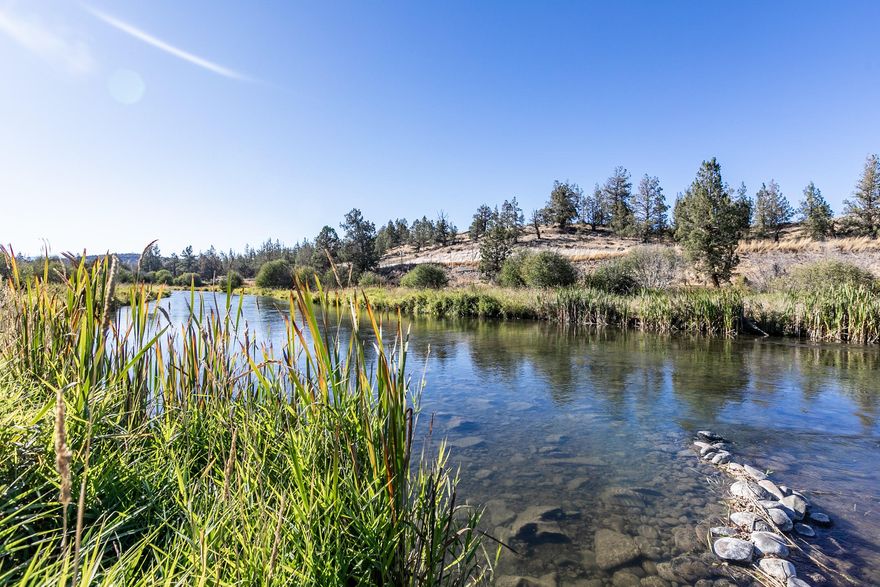 Experience the best of waterfront living on the pristine Deschutes River in the heart of Tumalo!  This gorgeous landscaped private estate offers 5 acres with a 3 acre lush irrigated pasture.  A unique multigenerational living opportunity with 4000 sf of living quarters with two master suites on the main level. The perfect place to invite friends and family over to enjoy the additional 1800 square feet of covered outdoor living space, outdoor fire pits, waterfall feature, play structure, kiddie pool, hot tub, wet bar and private beach. Accompanying the 4 car attached garage is a 5th RV bay and detached 24 X 40 insulated shop with RV doors. The builder/owner thought of every detail including an indoor/outdoor greenhouse, in-ground trampoline, woodshed, gym area, abundance of storage, large matching chicken coop with run, even a fenced orchard! Just a stones throw to the coveted Tumalo Community School, food trucks at The Bite, HIIT Logic and Coffeehouse. Easy access to Hwys and Downtown.