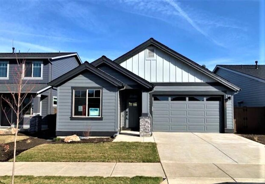 This beautiful new, single-level Wembley model has a comfortable, open design with 1,763 SqFt. The vaulted great room has a gas fireplace, large tall sliding doors/window leading out to a covered patio that is also accessible from the primary suite. Features 3-bedrooms (two suites), 2 ½ baths, and a 2-car garage. Trademark finishes include quartz countertops in the kitchen and the bathrooms, undermount sinks, luxury vinyl plank flooring downstairs and in the baths, solid Alder cabinets, and Smart Home Technology. Desirable lot location backing to the community walking trail, facing west, so eastern-facing covered patio will have morning sun and cooler late afternoon shade in the summer. HOA includes front yard lawn maintenance. Amenities include a seasonal pool, pavilion with a shared barbeque station and picnic tables, parks, and walking paths. Great location offering easy access to Bend. Photos of a similar home that may include upgrades, actual specs will vary. Floor Plan: WEMBLEY