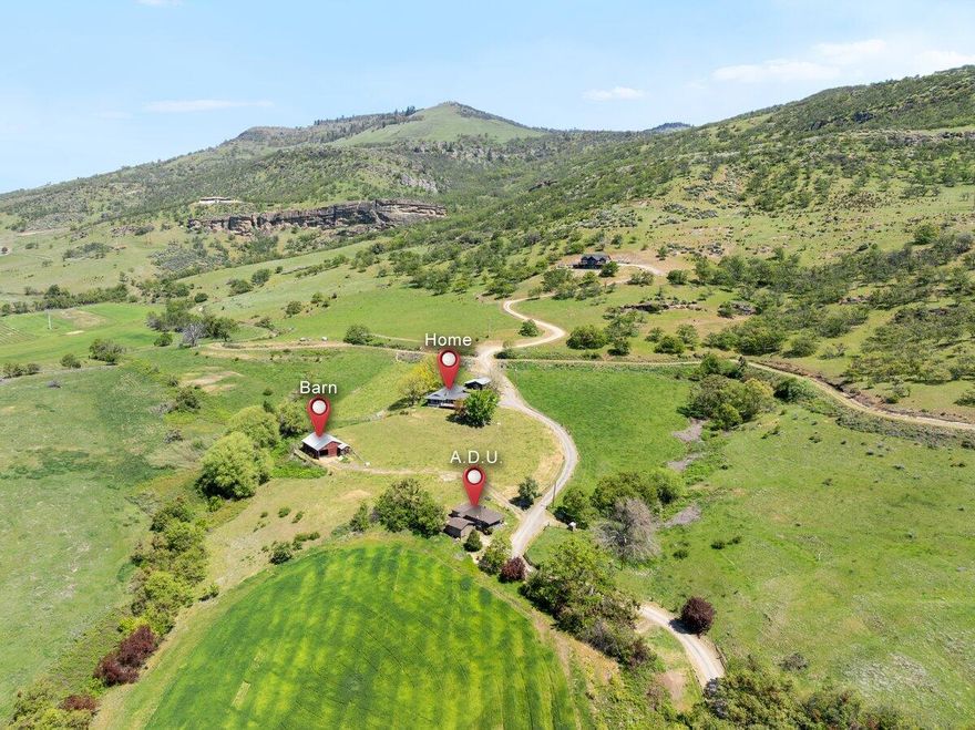 Set among premium rural estates, vineyards, & ranches, this 58+ acre EFU-zoned property features 2 homes & sweeping views of the valley, green pastures, vineyards & mountains. The majestic Payne Cliffs provide a stunning backdrop to the homesite. The main residence has been owned by the same original family & provides 3 bd, 2.5 baths & a spacious deck for taking in the panoramic scenery. The walk-out basement serves as a versatile/bonus space with 1/2 bath & direct access to the backyard. The second home is a 2-bd, 1ba dwelling, ideal for guests, extended family, or rental income. The property includes 11.5 acres of TID water rights & irrigation pods. The barn & pasture create the perfect horse/livestock setup, complete with squeeze chute. The land is fenced & located within 10 minutes of Ashland & 10 minutes of Medford. A rural country feel, yet only minutes from city conveniences & I-5 access. Schedule your tour of this incredible property today!