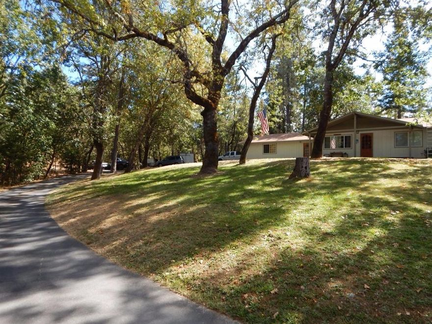 Wonderful Home On 5+ Private Wooded Acres! This 1976 Home was updated in 2010 and features 3 bedrooms, 2 baths, approx. 1911 sqft., open floor plan updated with Walnut hardwood, ceramic tile & Carpet flooring, and ceiling fans. The kitchen was updated with cabinets, granite tile counters & breakfast bar. Nice master bedroom w/walk-in closet and slider to deck. Large walk-through pantry, Lg. laundry room, newer heat pump and a wood stove. There are two decks, one partially covered and a wonderful large open patio with nice views of the beautifully wooded lot. Additional features include an attached oversized 2-car garage, attached carport, shed & nice detached small doll house. The circle drive makes access easy & there is plenty of room for RV parking and all the toys. Such a peaceful and private setting with seasonal creek. Not far from town, hospital and shopping. Call today!