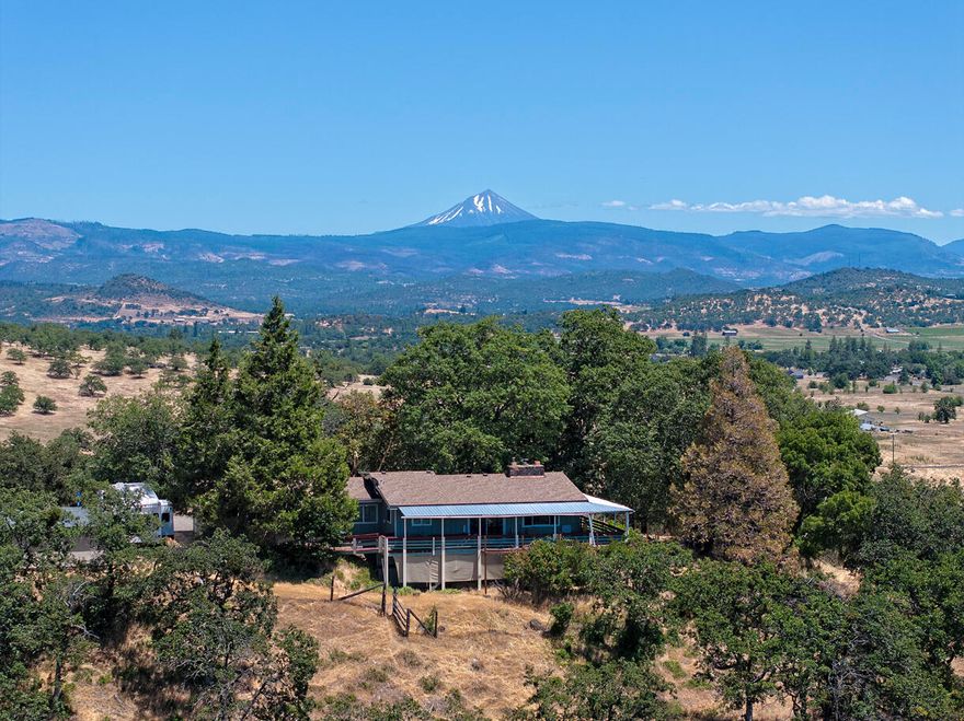 Outstanding views and privacy describe this home on six acres within the city limits of Eagle Point. The 3 bed, 3 bath home features main level living of 3162 square feet and additional daylight basement space. The home is perched on a knoll with views from Mt McLaughlin to the Table Rocks and beyond. You can also see the Eagle Point Golf Club along with many notable landmarks in the town. The home is poised for a remodel to make it your own. The property is nicely positioned for future development as recent subdivision activity is approaching this parcel. The home is served with city water. Additional outbuildings include a shop and barn. Value in location, views, existing structures and future development potential. Any purchaser to perform their own due diligence regarding uses and future development options.