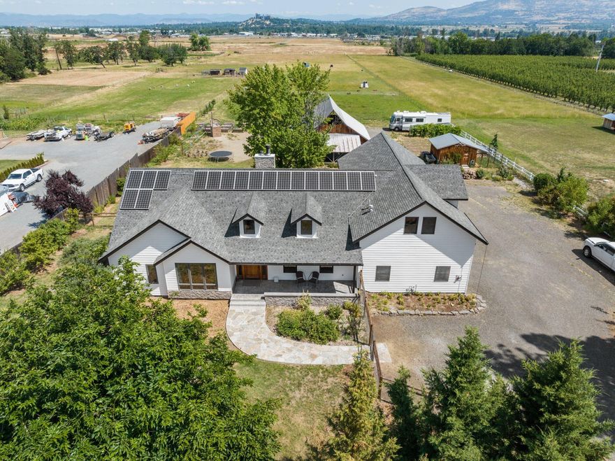 Discover this custom-built home w/ all the conveniences of city living but located just outside of town on a stunning 5.99 acre gated rural paradise! Incredible well delivering 35 GPM and irrigation rights for the whole property. Inside the home includes vaulted ceilings, Myrtle hardwood flooring and expansive windows creating an enchanting ambiance. Kitchen is equipped w/ all high-end appliances and stylish granite counters. The primary suite offers its own cozy fireplace, French doors, and a luxurious bathroom w/ walk-in closet. Two additional bedrooms and an office on the main level. Additionally, there's a large finished loft upstairs which is ideal for a two family setup. Outside, a large private deck w/ fireplace and jacuzzi hook-up awaits. The fully fenced property features a 2-car garage, RV parking, solar system, and a hay pasture. A restored 1940s barn and shed/chicken coop add charm! Ask for the Property Features Sheet!