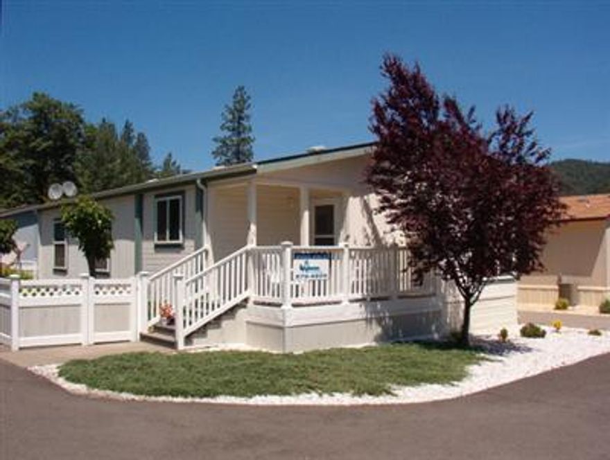 Upgraded 2 bedroom, 2 bath Palm Harbor home w/an extra large fenced lot with double gate. Fencing is a beautiful white picket-style all-weather type. Entry steps and deck are low maintenance type. Nicely landscaped, low maintenance drip irrigated yard. Good views. Great floor plan w/wrap around windows. Has shop and storage shed.