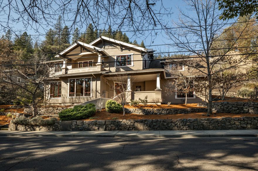 Sitting on Ashland's most sought after street, this gorgeous contemporary Craftsman home overlooks Lithia Park and its upper duck pond while being just blocks to the Plaza. It also sits at the foot of Ashland's extensive trail network, making this an unbeatable location. This stunning home features hardwood floors, three fireplaces and custom doug fir built-ins throughout. The chef's kitchen has a large island, stainless appliances, including a wine fridge. The great room has double height ceilings- filled with natural light. A dedicated movie room rounds out the living space. Upstairs (via stairs or elevator) has an amazing primary suite with fireplace, three additional bedrooms, two ensuite- one a perfect in-law set up with a separate entrance. Lovely landscaping, mature trees, an outdoor fireplace and a swim/spa all add to this amazing property. This is a must-see home!