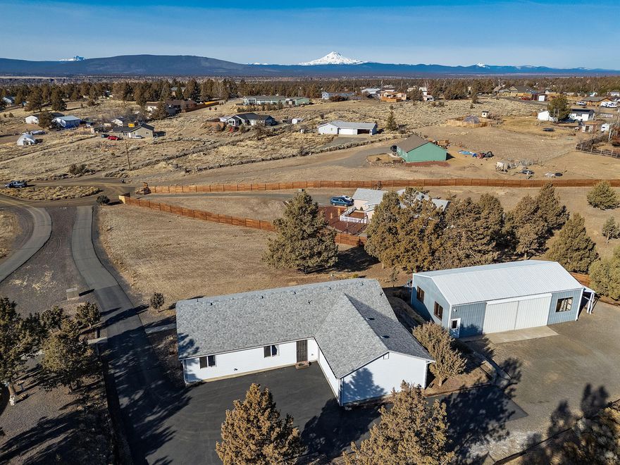 Cascade Mt views on 1-acre lot, coupled with a well-cared for 1568 Sq Ft home, attached, finished, 2-car garage & 1152 Sq Ft, heated & insulated, shop, with concrete floors, dbl sliding-door entry, man-door to shop.  Enjoy the views from the large living/dining windows, or the massive deck that wraps around the house.  The asphalt drive meanders up the slightly sloped lot, to the attached garage, with a gravel drive to the large shop.  Inside you will enjoy a great room concept, with free-standing propane stove and large breakfast bar.  Primary en-suite is large, with walk-in closet, in addition to Mt. views.  Guest rooms are ample size as well.  The laundry room takes you outside, or into the attached garage, through a mud room, with lots of room for freezer and additional storage.  Enjoy all that Crooked River Ranch has to offer; with 18-hole golf course, outdoor swimming pool, Bocce Ball, tennis/pickleball, disk golf, horse arena & special interest clubs for everything imaginable!