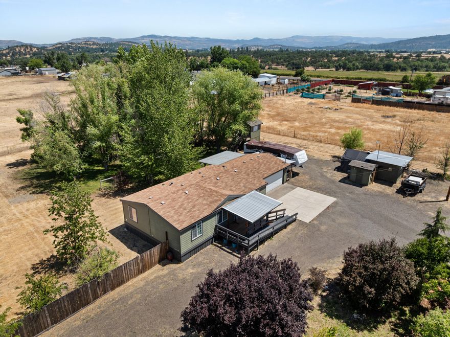 Well maintained home on 2 full ACRESof pasture land, a koi pond with waterfall, fruit trees, garden boxes, multiple sheds, fencing and cross-fencing, and VIEWS. This lovely home has some updates throughout, such as laminate flooring, paint, and a 2-year old detached ''granny unit''. This detached unit is 400 sf with a bedroom area and walk-in closet. It's fully finished with lighting, heat/ air and electricity but the garage door was left in tact and could be converted back if a 2-car garage is so desired. This space has a hallway with a refrig that leads into an RV that the home owners utilize as their kitchen and bathroom, so this property was intentionally set up to house 2 generations. The RV can be included. The land has a multiple RV hookups w/ dumps, is gated with 2 driveways. Make this private and pretty place yours!