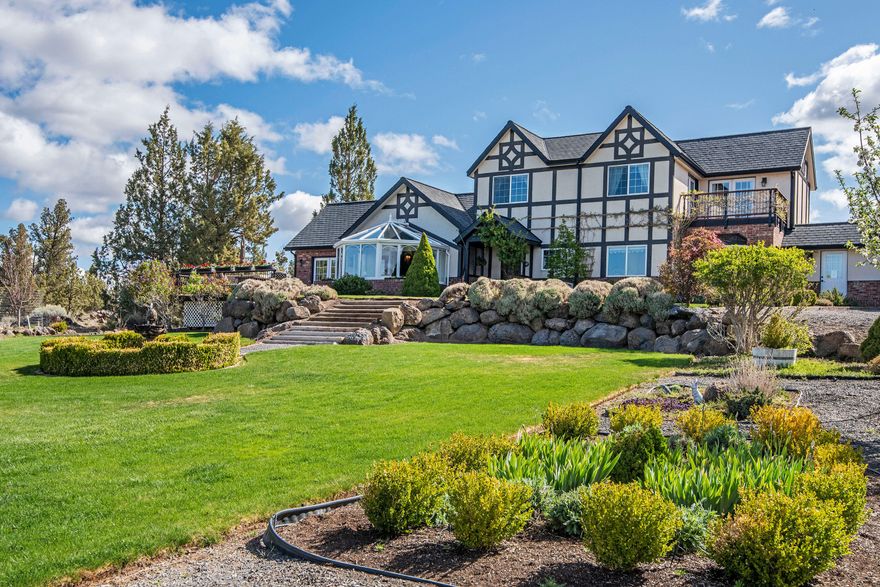 This true English Tudor home sits on 5+ acres in the Tumalo area with panoramic Cascade Mountain views from Mt. Bachelor to Mt. Jefferson. The grounds are impeccably maintained and include a large fenced vegetable garden with several varieties of berries. The 3,040 sq. ft. home features quality finishes throughout, a large main level master suite with gas fireplace, and a large gourmet kitchen. There is also a conservatory, bought and shipped from England to take advantage of those amazing views, a 240 sq. ft. shop/office space off of the oversized garage, and an unfinished bonus room over the garage. In addition, there is a 1,360 sq. ft.  shop with a 40' deep RV bay with a 14' garage door, and 2 additional bays.