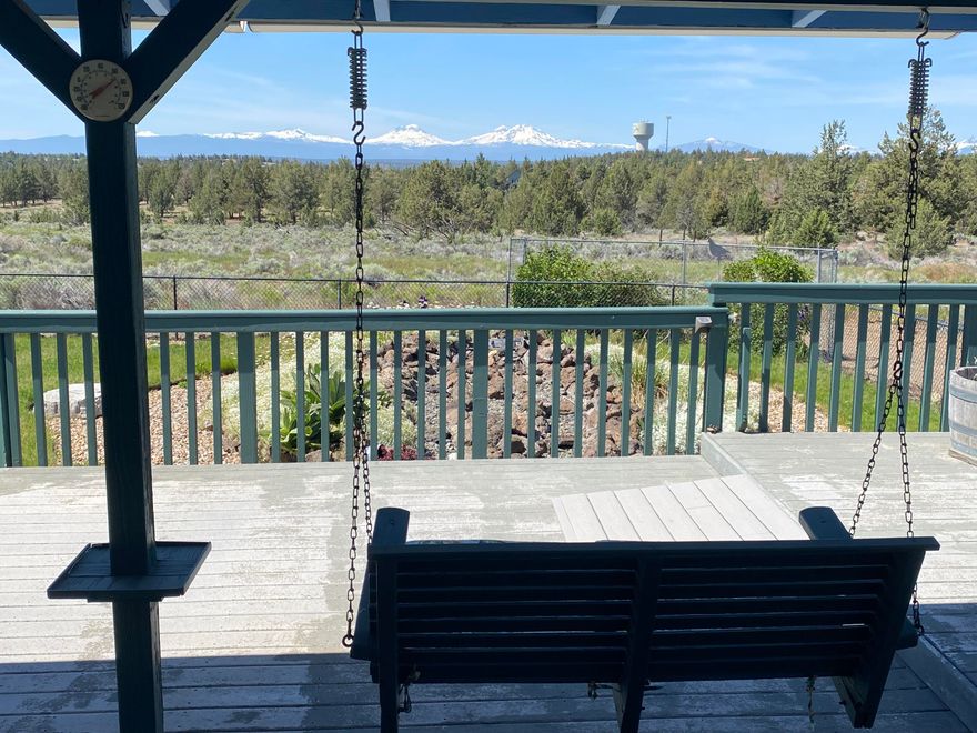 Welcome to your slice of paradise in Crooked River Ranch! This beautiful single-level home offers stunning panoramic views of the Three Sisters, Broken Top, Mt. Jefferson, and more—right from your backyard. Relax on the spacious Trex deck with a hanging swing and soak in the scenery. Inside, the open living and dining area are perfect for entertaining, and the custom kitchen features quartz countertops, quality cabinetry, space for dining, and access to the front porch deck. The primary suite includes two walk-in closets and a remodeled bathroom with dual sinks and a large walk-in shower. Two additional bedrooms and a spacious utility room with pantry storage add to the home's comfort. Outside, enjoy a fully fenced yard with a serene water feature. The oversized garage includes a built-in air compression system and two bonus rooms ideal for hobbies or storage. This home truly offers some of the best views in Crooked River Ranch. Call your favorite agent to come see it today!