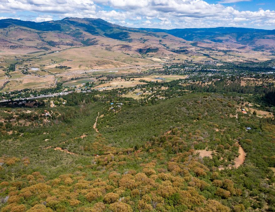 Gorgeous, private, 80-acre lot only 7 minutes from downtown Ashland! The land is wooded and lush with native Oak and Madrone trees, abundant wildlife, and more. There are sensational 270 degree views of the valley and the hills to the northeast and south. The land is largely sloping but has ample flatter sections to build your dream home, have a garden and a yard. The possibilities are endless. Homesite approval, building pad and private driveway to property in place. Don't miss this unique opportunity to own acreage only minutes to downtown Ashland!  Please no drive-by for this property without permission from the listing agents.