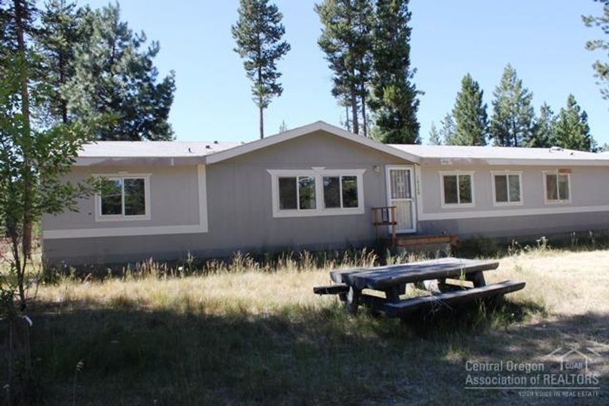 Great setting in the pines for this home with detached garage plus a shop. Home needs some TLC but has tons of potential. Spacious 1+ acre lot.