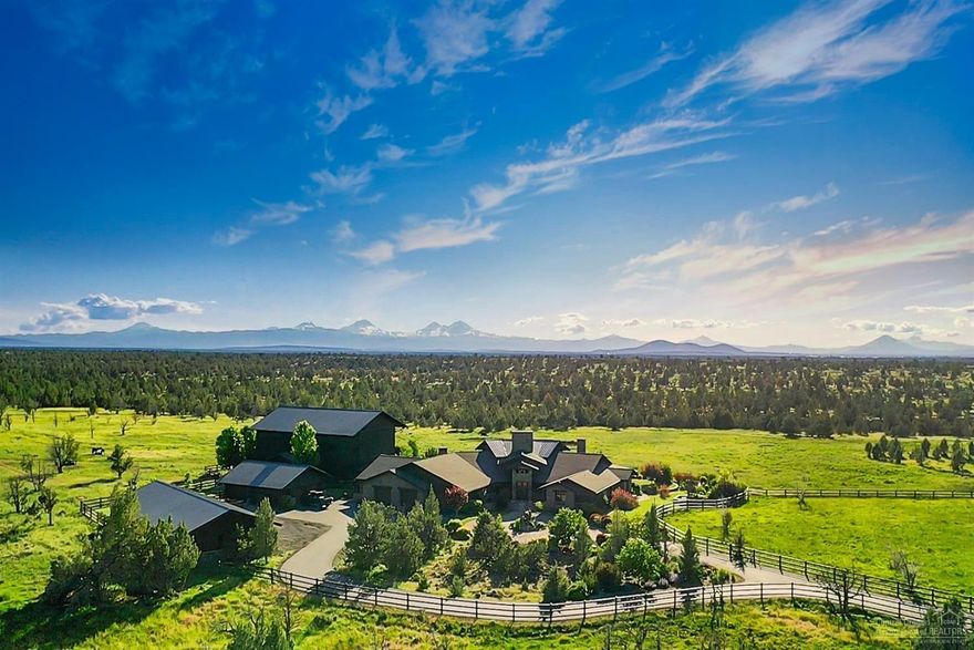 Welcome to Y Bell Ranch, an extraordinary 435-acre retreat in Powell Butte, Oregon, just eight miles from Redmond Municipal Airport—ideal for West Coast travelers seeking privacy and high-desert tranquility. The single-level 8,863 sq ft primary residence showcases exceptional craftsmanship, using stone sourced from the property and framing sweeping Cascade Mountain views. The open layout supports effortless indoor-outdoor living, highlighted by a chef's kitchen with Monogram appliances and dual islands, plus a family room with full bar and game area. Additional spaces include a theater, exercise room, office, and children's media room with its own bathroom. The serene primary suite features a rock fireplace, private patio, walk-in shower, and soaking tub, with three additional en suite bedrooms for guests. Outdoor living shines with a covered patio equipped with propane heaters, fans, rock fireplace, and media setup.