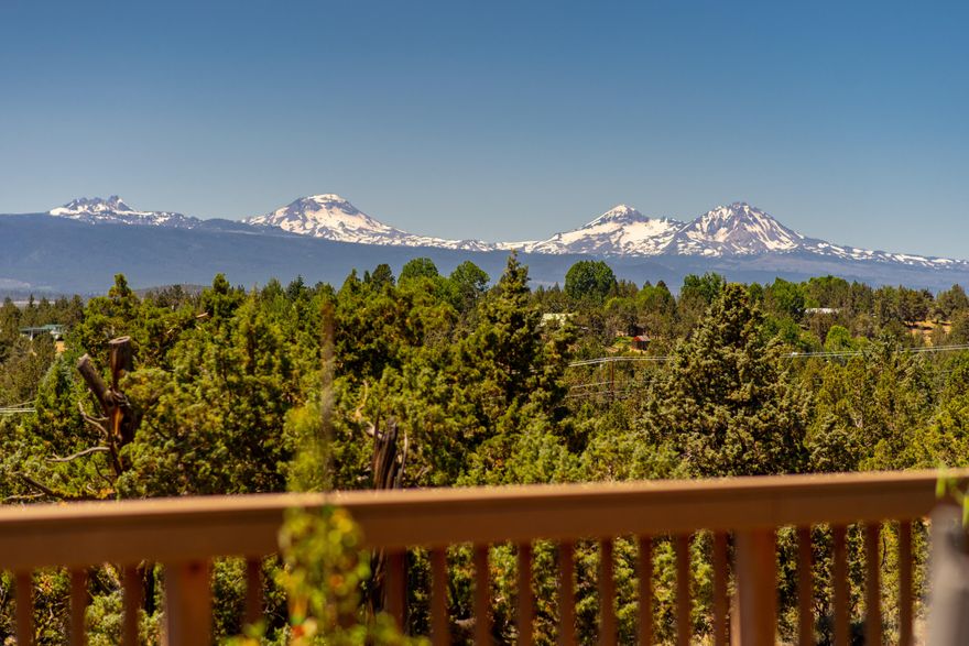 Tucked into a quiet cul-de-sac, with sweeping views of green fields and the Cascade Mtns beyond, this one of a kind home is overflowing with possibilities. The carefully crafted main living area features vaulted tongue & groove ceilings that run the full length of the spacious dining, kitchen and living areas. An expansive view-facing deck brings the beauty of the mountains to you in a perfect spot for outdoor dining & entertaining. The view-facing primary suite includes a cozy gas fireplace, generous bathroom with jetted tub & dual vanity. One additional bedroom, a full bath & oversized pantry complete the west wing. Across an attached four car garage, you'll find additional living space, perfect for multi-generational living or work from home opportunities with a full bedroom & bath, extra large bonus room & room for an office. On over 2.5 acres, this property includes a charming greenhouse, fenced garden & orchard, solar energy, 2 RV parking spots & just the right amount of lawn.