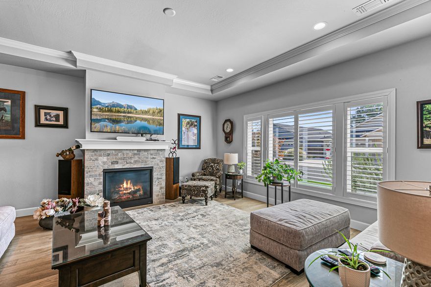 Designed for comfort and convenience, this Snowy Butte Station home features a popular great room floor plan with vaulted/coffered ceilings, hardwood floors in the main living areas, and a cozy gas fireplace. The kitchen shines with granite counters, tile backsplash, stainless steel appliances including a 5-burner range, soft-close cabinetry, and a huge walk-in pantry. The primary suite includes a walk-in closet and dual-sink vanity. Enjoy a covered patio, fenced side yard, and oversized 2-car rear garage with utility sink. HOA maintains front landscaping, with a pocket park just down the street.